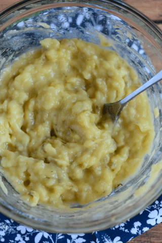 mashed bananas in mixing bowl with spoon