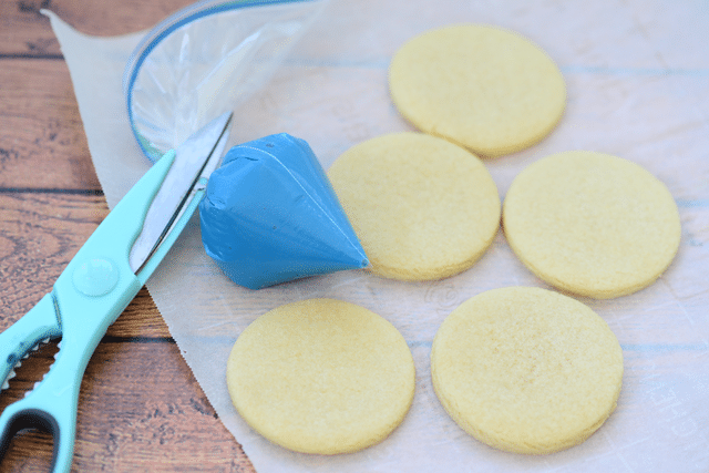 sugar cookies with blue icing in a bag on parchment paper 