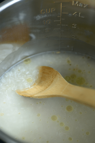 white rice, water, wooden spoon, oil in instant pot