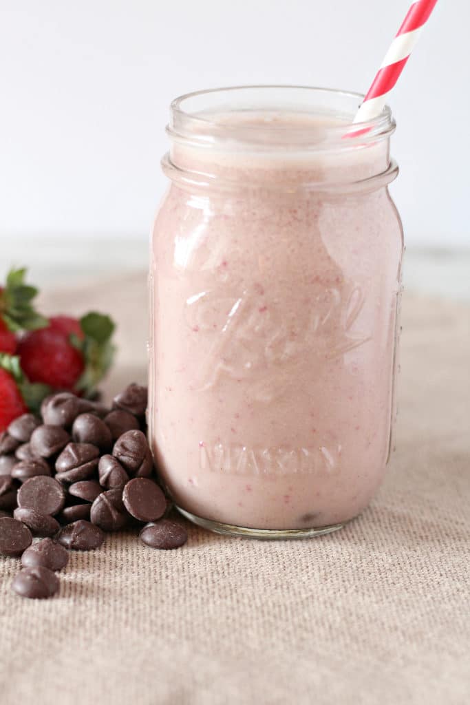 vertical picture of a strawberry smoothie in a mason jar