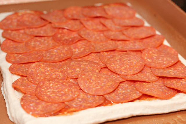 pizza crust with pizza sauce and pepperoni