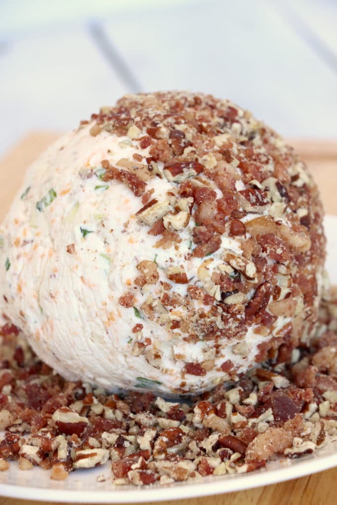 Bacon Cheese Ball with Bleu Cheese being rolled in bacon and pecans