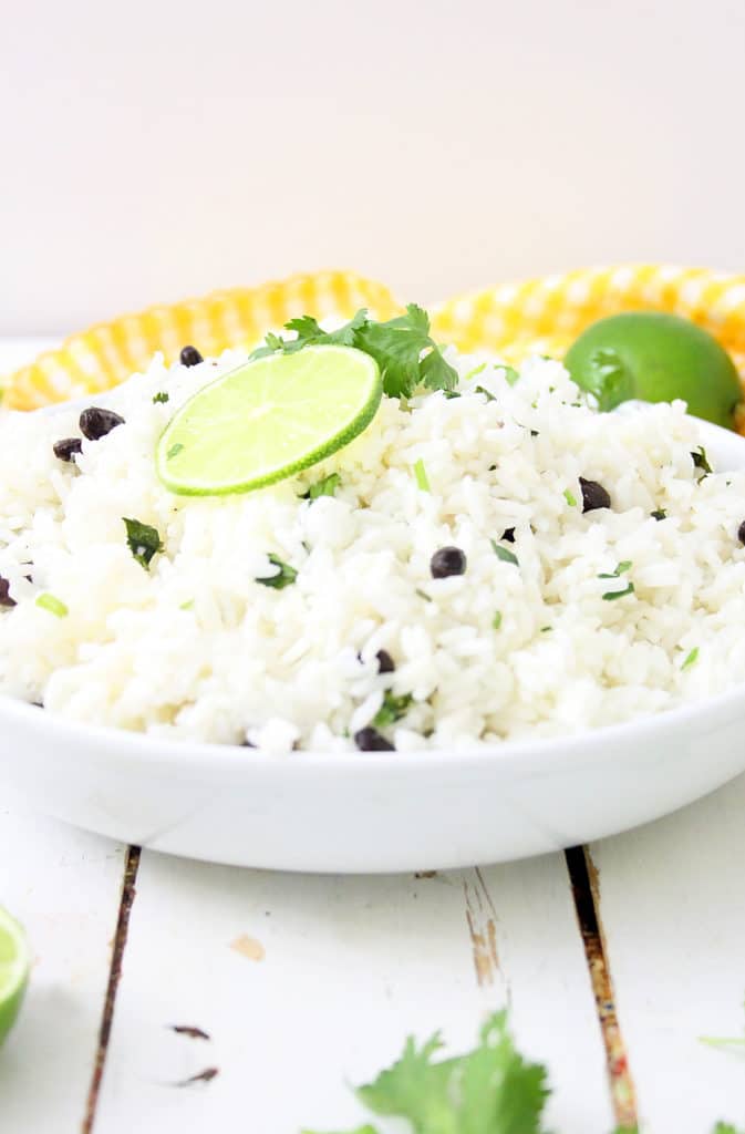 lime rice in a white bowl with limes on top