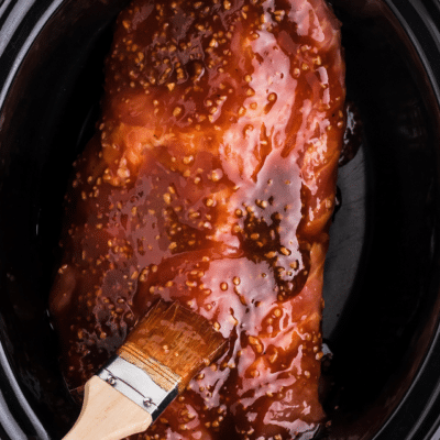 brushing sauce on crockpot pork tenderloin
