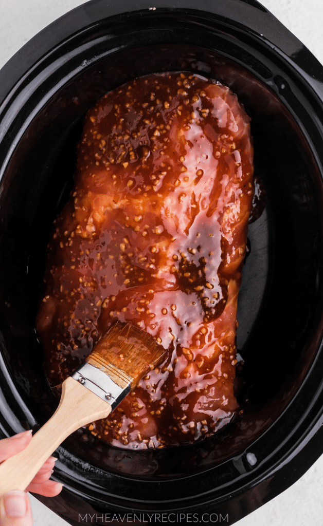 brushing sauce on crockpot pork tenderloin